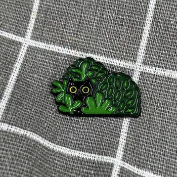 Černá kočička v zelených keřích