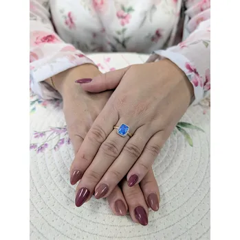 Prsten Zlatý dámský prsten s modrým kamenem zdobeným zirkony Velikost prstenu: 56, Váha: 2,55gr, Ryzost: 14kt (585/1000)