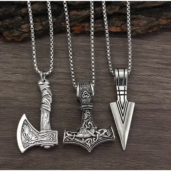Sekera Masivní severský náhrdelník – 3 varianty (Sekera, Thorovo kladivo, Hrot šípu) Metal: ​1. Vikinská sekera: Detailně zdobená válečná sekera, často spojovaná se statečností a silou bojovníka.