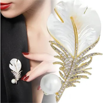 Brož Zlatá elegantní brož ve tvaru pírka se zirkony a perličkou, ozdobná sponka pírko