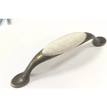 Nábytkové kování 62144-úchytka 96mm staromosaz porcelán popraskaný (Úchytka kombinující kov ze staré mosazi a vložku z bílého porcelánu s popraskaným efektem (craquelé). Rozteč 96mm. Autentický vintage a usedlý vzhled.)