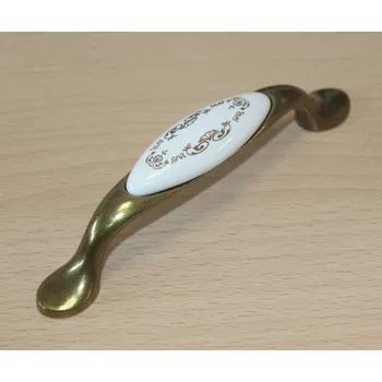 Nábytkové kování 11083 - úchyt 96mm mosaz - porcelánový zlatý ornament (11083 - úchyt 96mm mosaz - porcelánový zlatý ornament v povrchu mosaz. Jednoduchý a funkční doplněk do interiéru.)